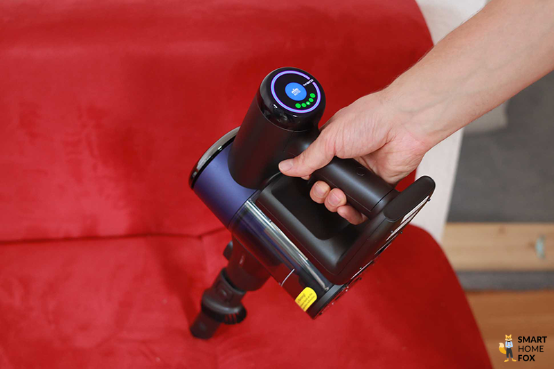 Die Mini-Elektrobürste beim Absaugen des Sofas